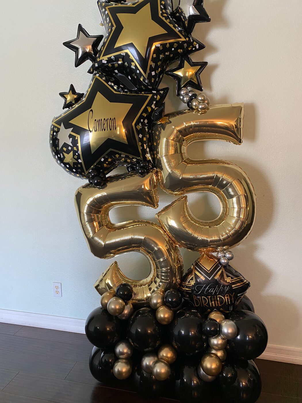 Black and gold star and number 55 balloon tower