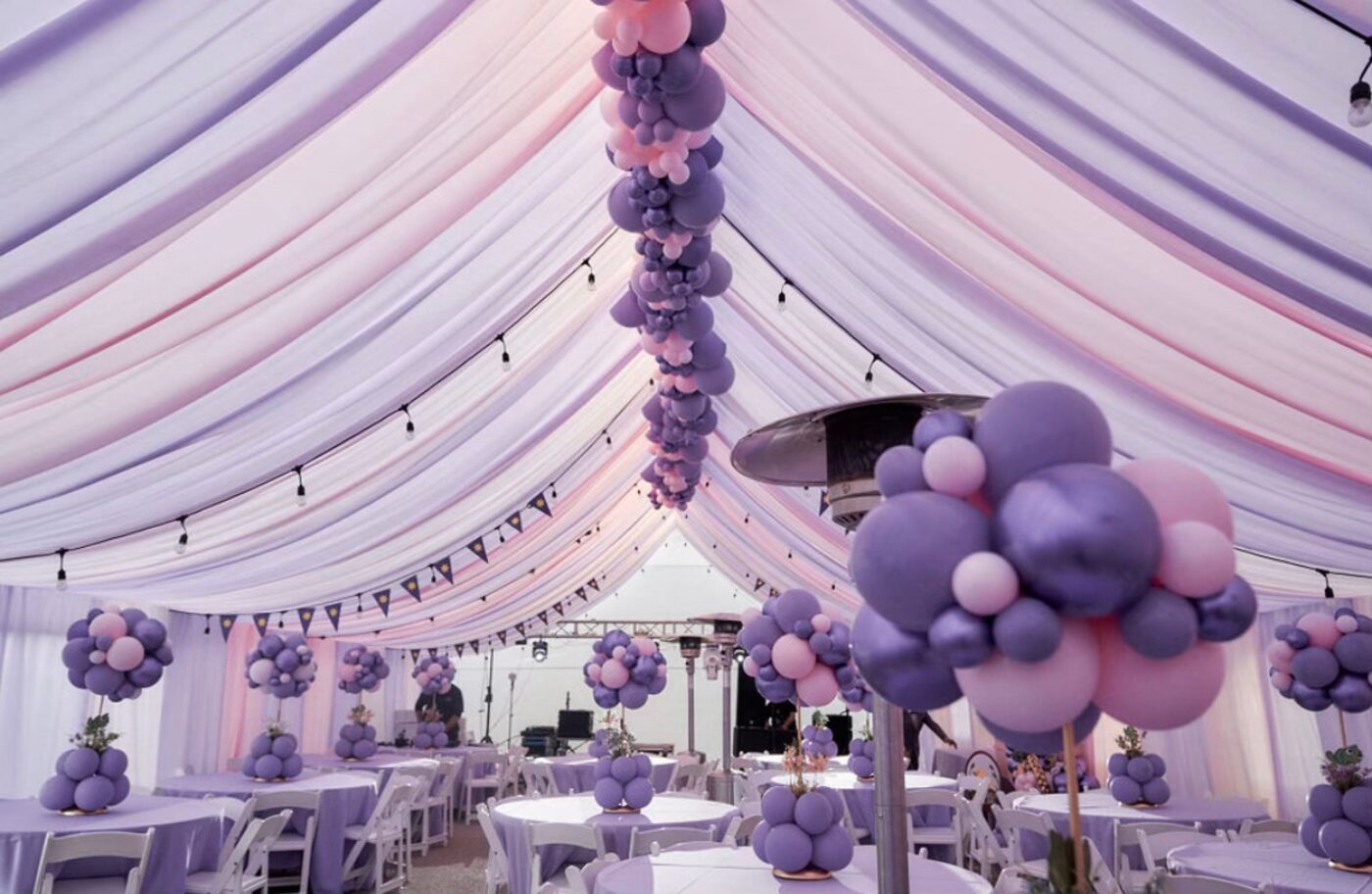 Lavender and pink garlands hanging in a draped white tent